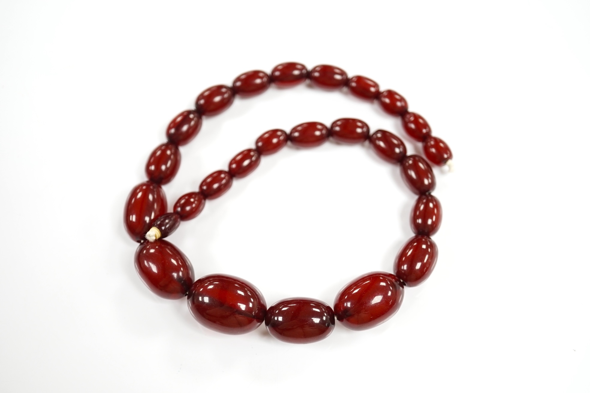 A single strand graduated oval simulated cherry amber bead necklace, 38cm, gross weight 41 grams. Condition - poor to fair